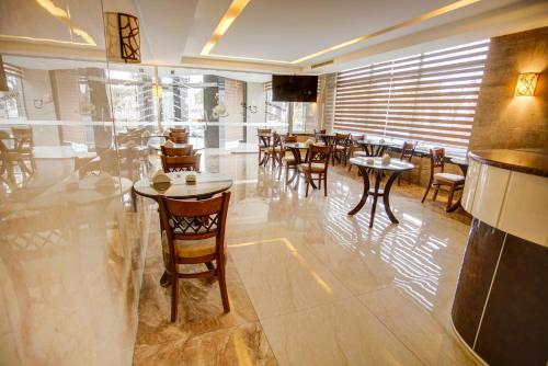 a restaurant with tables and chairs in a room at Nairoukh Hotel Aqaba in Aqaba