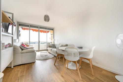 un salon avec une table et des chaises dans l'établissement Bright Apt With Balcony And Sea View, à Antibes