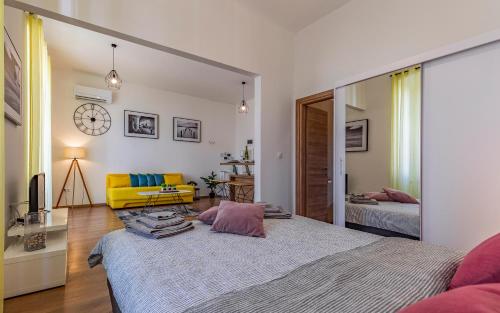 1 dormitorio con 1 cama grande y 1 silla amarilla en Apartment Dream Pula - City Centre, en Pula