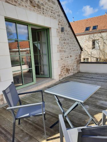 een picknicktafel en stoelen op een patio bij LE RELAIS in Révillon