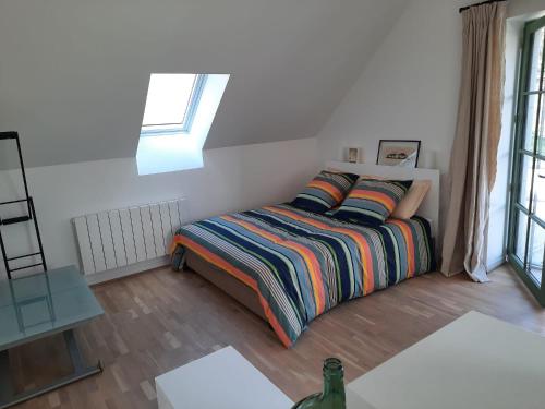 een kleine slaapkamer met een bed en een raam bij LE RELAIS in Révillon