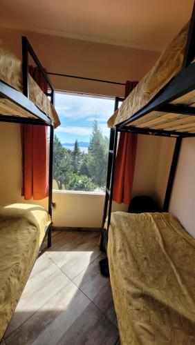 two bunk beds in a room with a window at Astrolabio Hostel in San Carlos de Bariloche