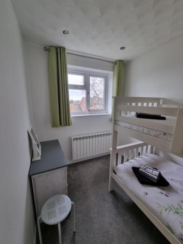 a small bedroom with a bunk bed and a desk at Anniversary Cottage- Country feel, close to Cromer in Northrepps