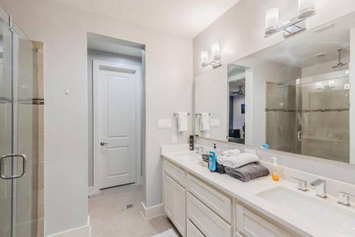 a white bathroom with a sink and a shower at Stunning Townhome Near Uptown in Dallas