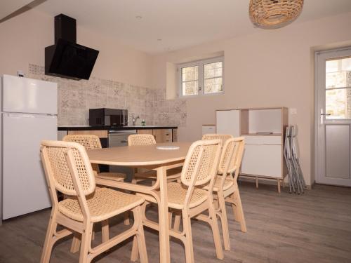 a kitchen with a table and chairs and a refrigerator at Les Clématites de Saint-Aignan 8p, 7min du Zoo in Saint-Aignan