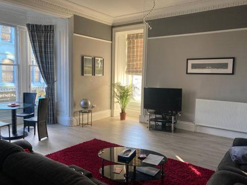 a living room with a couch and a table at Luxury Apartment at Barron House in Nairn