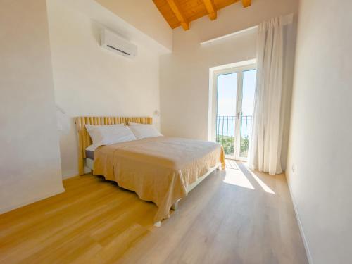 um quarto com uma cama e uma grande janela em Villa Beole em Bardolino
