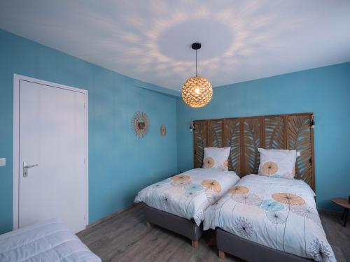 a bedroom with two beds with blue walls and a ceiling at Les Clématites de Saint-Aignan 8p, 7min du Zoo in Saint-Aignan