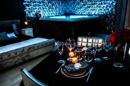 a dining table with wine glasses and a bath tub at Velezia LOVE in Roujan