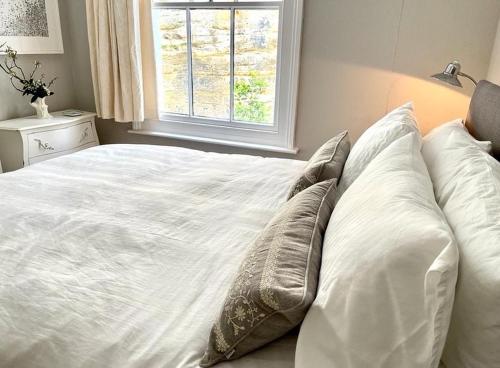 a white bed with pillows in a bedroom with a window at Gloucester House in Hastings