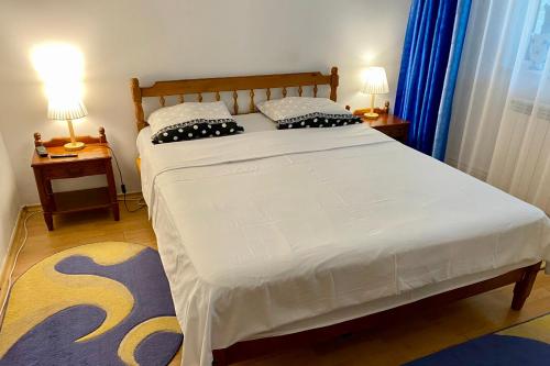 ein Schlafzimmer mit einem großen Bett mit zwei Lampen an Tischen in der Unterkunft Serene Apartment Navodari in Năvodari
