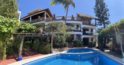 una casa grande con piscina frente a ella en Casa Terranova en Puerto Escondido