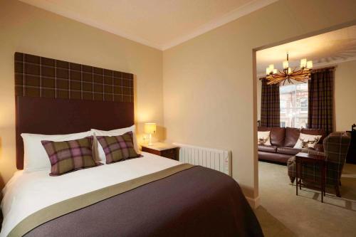 a bedroom with a large bed and a living room at Downright Gabbler in Beauly