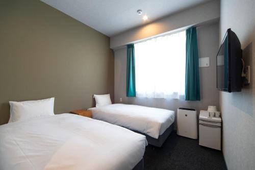 a hotel room with two beds and a window at IMANO OSAKA SHINSAIBASHI HOSTEL - Vacation STAY 27589v in Osaka