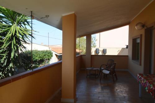 Habitación con balcón con mesa y sillas. en Casa della Salsedine, en S'Archittu