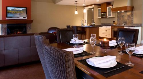 un comedor con una mesa con copas de vino en Solara Resort by Bellstar Hotels, en Canmore