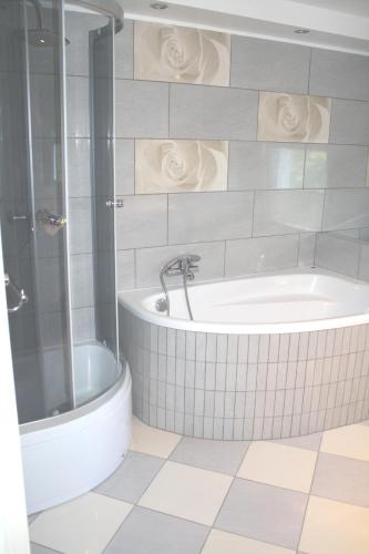 a bathroom with a tub and a shower at Zajazd u Sosny in Torzym