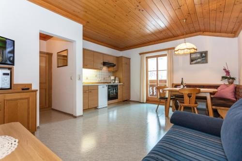 a living room with a table and a kitchen at Biobauernhof Stegerbauer in Maria Alm am Steinernen Meer