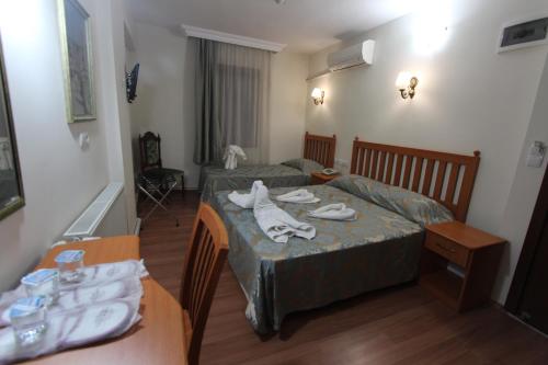 a hotel room with two beds with towels on them at Hotel Ave Maria in Selcuk