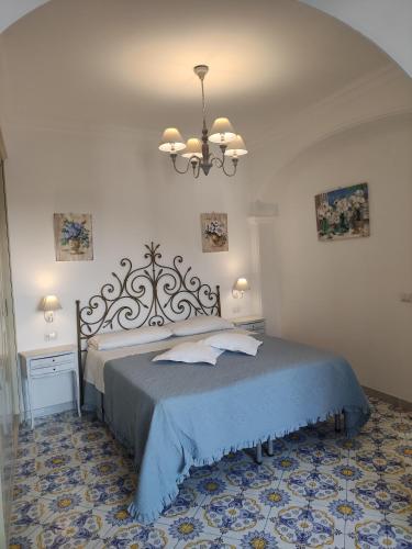 a bedroom with a bed and a chandelier at B&B Villa Cristina in Anacapri