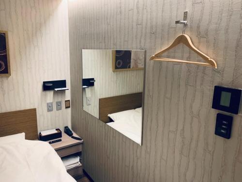 a mirror on a wall in a room with a bed at Takahashi Building 3rd and 4th floors - Vacation STAY 24477v in Musashino