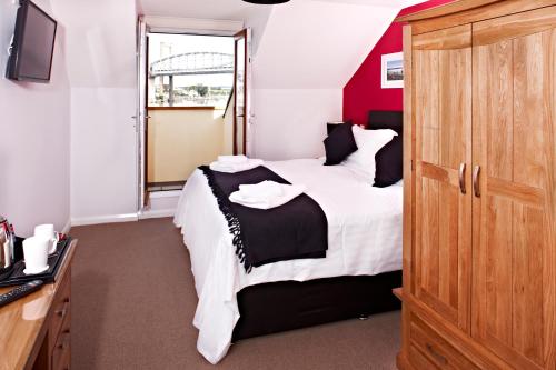 a bedroom with a large bed and a window at The Ferry House Inn in Plymouth