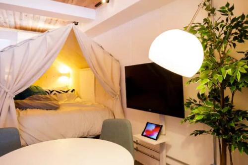 a bedroom with a bed and a tv and a table at Ōgi-en building 3 - Vacation STAY 12594 in Tokyo