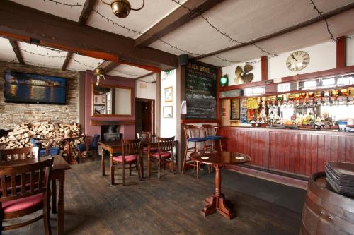 a restaurant with a bar with wooden tables and chairs at The Ferry House Inn in Plymouth