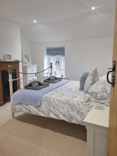 a bedroom with a bed with a blue comforter at Cosy Cottage, in the idyllic town of Holt in Holt