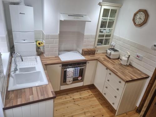 a small kitchen with a sink and a stove at Cosy Cottage, in the idyllic town of Holt in Holt