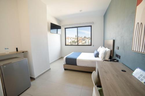 a bedroom with a bed and a table and a window at TH HOTEL & VIVIENDA in Tepatitlán de Morelos