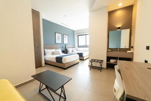 a living room with a bed and a couch at TH HOTEL & VIVIENDA in Tepatitlán de Morelos