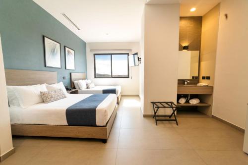 a bedroom with two beds and a chair in it at TH HOTEL & VIVIENDA in Tepatitlán de Morelos