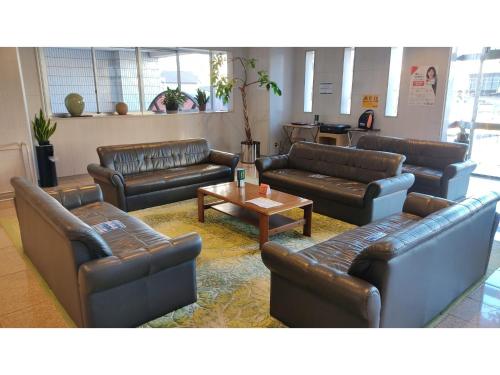 a living room with leather couches and a coffee table at Central Hotel Toride - Vacation STAY 09921v in Toride