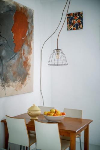 a dining room table with a bowl of fruit and a lamp at Ecocirer Guest House in Sóller