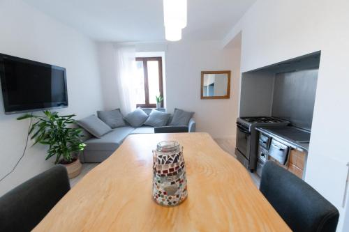 sala de estar con mesa y sofá en Appartamento Trentino, en Molina di Ledro