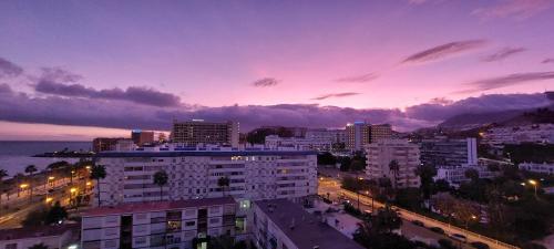 Una vista de una ciudad de noche con edificios. en Maite Beach Vibe, en Benalmádena