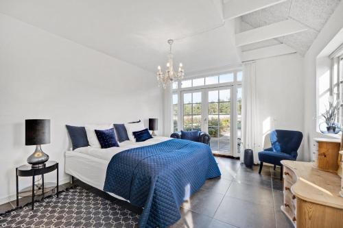 a bedroom with a bed and a chandelier at Lildgaard in Frøstrup