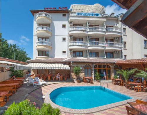 um hotel com piscina em frente a um edifício em Hotel Eos em Kiten