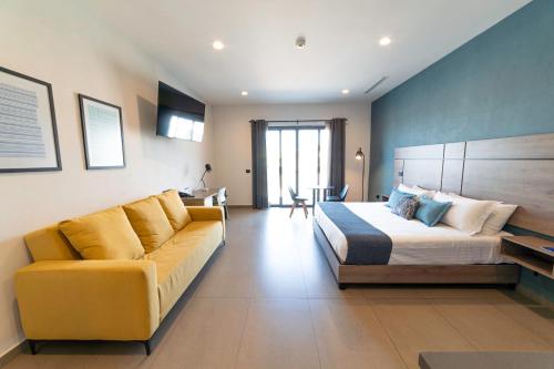 a hotel room with a bed and a couch at TH HOTEL & VIVIENDA in Tepatitlán de Morelos