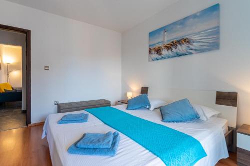 a bedroom with two beds with blue towels on them at Apartment Brđanović in Cres