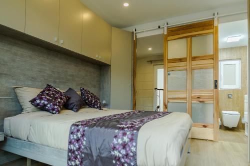 a bedroom with a large bed and a bathroom at Ta' Ġilard - Lovely Renovated Holiday Home in Żabbar