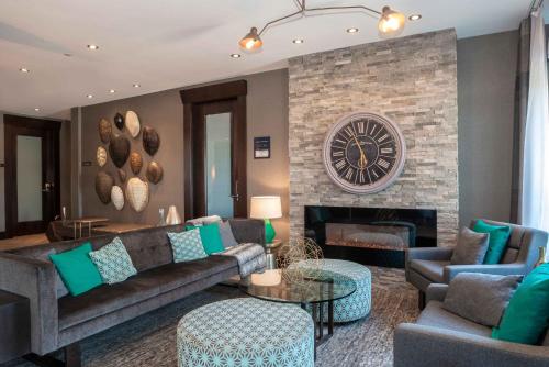 a living room with a couch and a fireplace at Sandman Hotel Oakville in Oakville