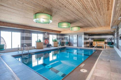 a large swimming pool with blue water in a building at Sandman Hotel Oakville in Oakville