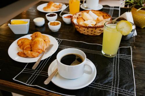una mesa cubierta con platos de comida y una taza de café en Posada Yvoty en Puerto Iguazú