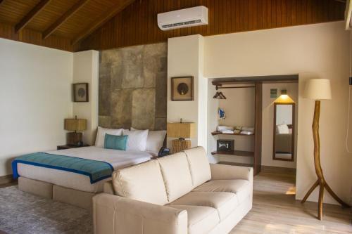 - une chambre avec un lit et un canapé dans l'établissement G Boutique Hotel at San Andres Peten, à San Andrés