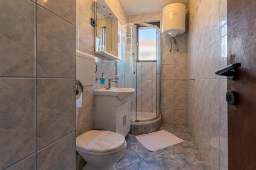 a bathroom with a toilet and a shower and a sink at Apartment Brđanović in Cres
