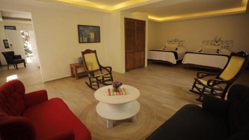 a living room with a couch and a table and a bedroom at Hotel La Casa de los Árboles Immersive Experience in Zacualpan de Amilpas