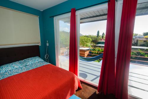 a bedroom with a bed and a large window at Aparthotel Pelican's Surf Club in Nueva Gorgona