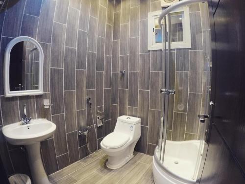 a bathroom with a toilet and a sink and a shower at شاليهات ليالي زين الشرف 1 in Taif